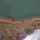 Aerial View of the Shore of a Big Forest Lake Showing the Clear Water the Sandy Beach and the Trees - VideoHive Item for Sale
