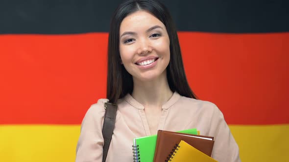 Smiling Female With Notebooks on German Flag Background, Academy Course, Student