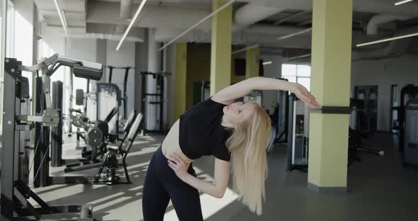 Young Active Athletic Blonde Girl Works Out in the Gym