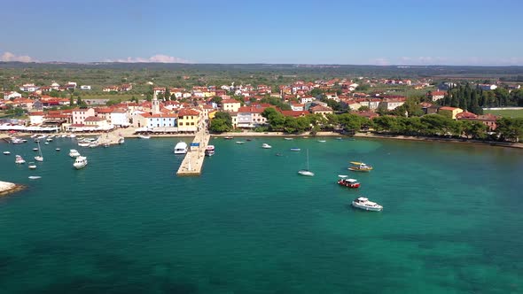 Flyby the shore of the historic town Fazana with harbor and beach in Croatia 