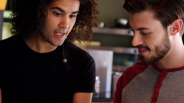 Two men interacting with each other while using digital tablet