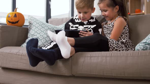 Kids in Halloween Costumes with Tablet Pc at Home