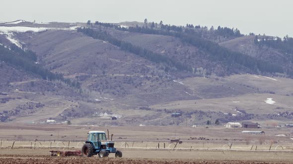 Farmer plowing field with tractor in the countryside of Wyoming