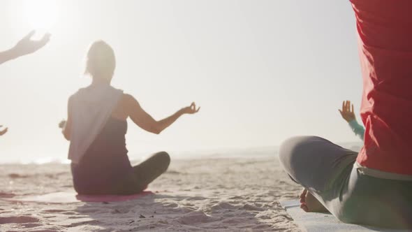 Athletic women performing yoga in the beach