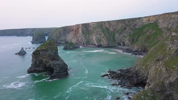 Beautiful turquoise waves by the rocky mountain shoreline -Bedruthan Steps England -aerial