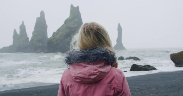 Woman Travel is Walking Along Reynisfjara Beach or Black Sand Beaches in Rain Weather Conditions