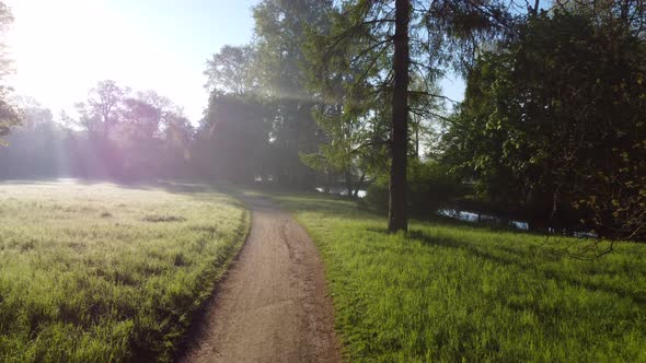 Aerial Drone View Flight Over Dirt Path in Park in Early Morning