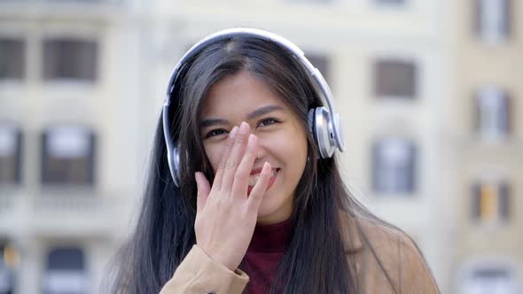 Happy smiling asian pretty woman with headphones in the city- slow motion