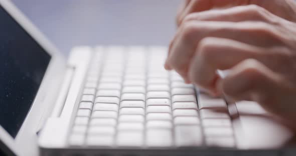 Closeup of Male Hands Typing Laptop Keyboard