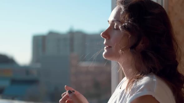 A Young Woman Takes Off a Medical Mask Breathes Deeply and Smiles While Looking at the World