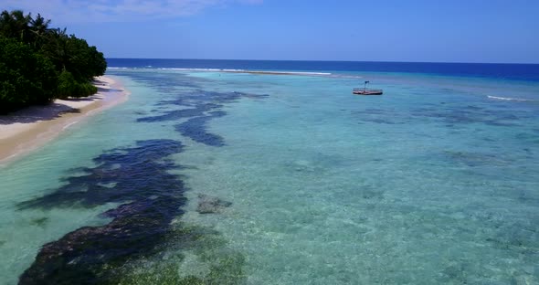 Wide birds eye island view of a white sand paradise beach and aqua blue ocean background