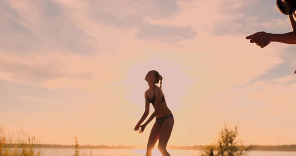 Beach Volleyball Match Girls Hit the Ball in Slow Motion at Sunset on the Sand.