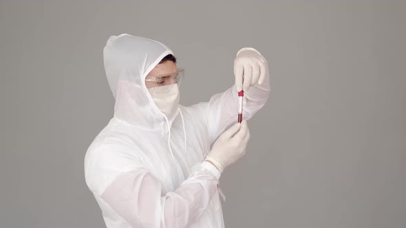 Male Scientist in Full-covering Equipment Is Examining a Blood Test in a Laboratory