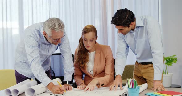 Businesswoman and coworkers discussing blueprint