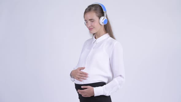 Young Happy Pregnant Businesswoman Listening To Music