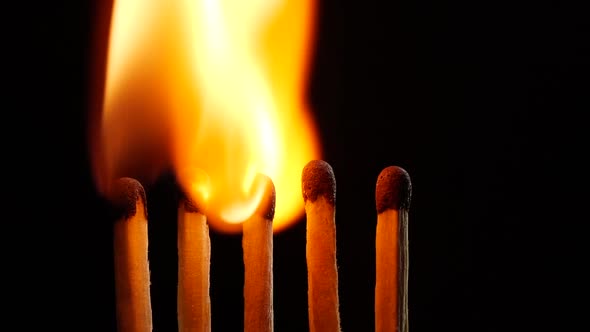 Slow motion of igniting and burning a matchsticks over black background