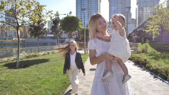 Cheerful Mom with Girls Spending Leisure Outdoors