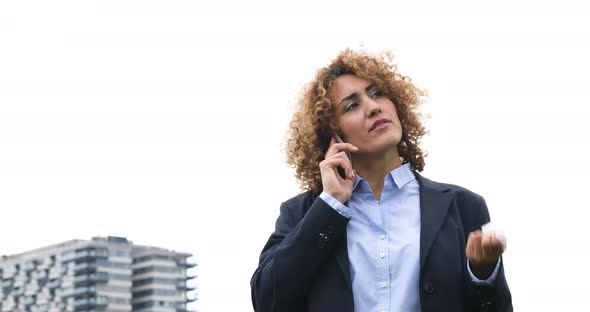 Businesswoman using smartphone and holding glasses
