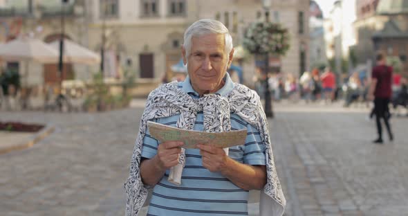 Senior Male Tourist Exploring Town with a Map in Hands. Looking for the Route