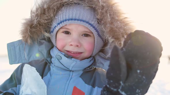 Happy Child with Fun Laughing in Winter Park on a Sunny Day