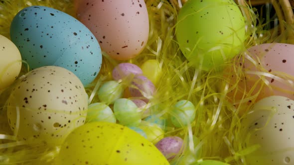 Rotating shot of Easter decorations and candy in colorful Easter grass 