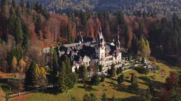 Aerial drone view of The Peles Castle in Romania. Castle with gardens in Carpathians, forest around 