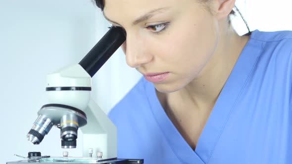 Female Doctor using Microscope in Laboratory for Research