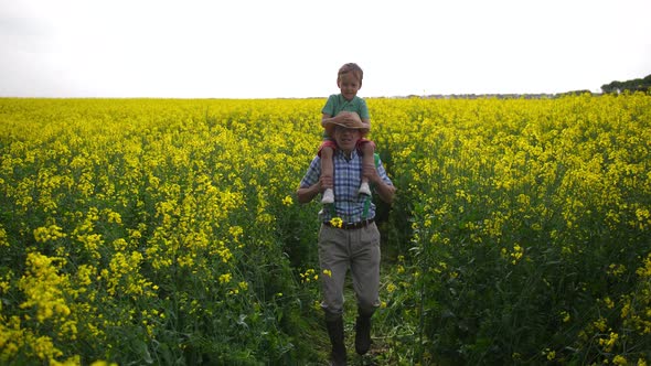 Happy Farmer and Grandson During Walk Among Plants