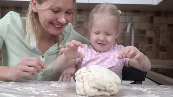 Happy Family Mom and Daughter are Preparing Pastries From the Dough in the Kitchen