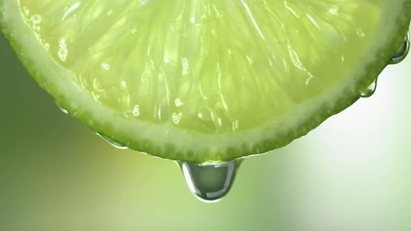 Slow Motion Macro Shot of Flowing Lime Juice From Lime Slice