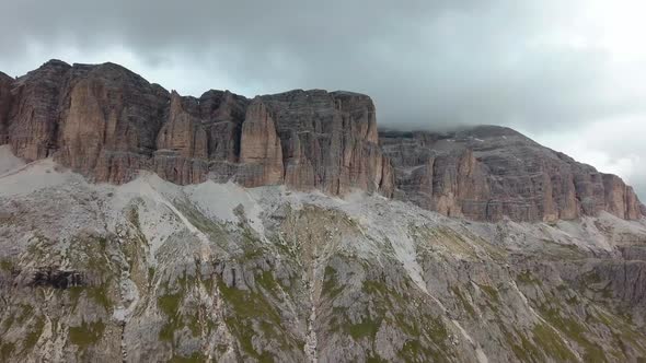 Dolomite mountain rock formation in northern Italy cloudy skies in a winter day, Aerial drone right