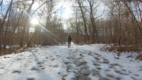 Man Hiking in White Winter Forest with Backpack. Recreation and Healthy Lifestyle Outdoors in Snowy