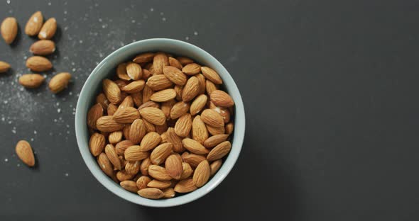 Video of fresh fruit almonds in a bowl on grey background