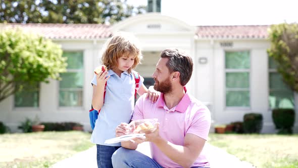 Happy Dad and Kid Having Lunch Outside the School Slow Motion Fatherhood