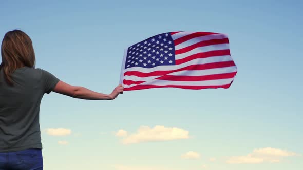 Woman Holds Usa Flag Against Blue Sky