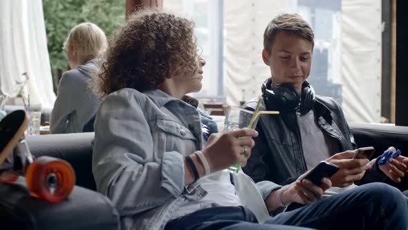 Teenagers Using Gadgets in Outdoor Cafe