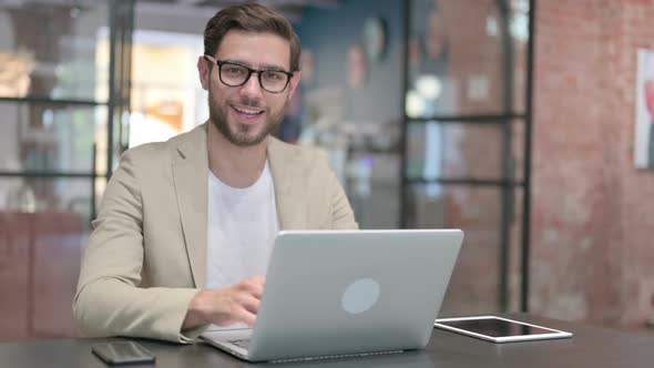 Thumbs Up By Young Man with Laptop