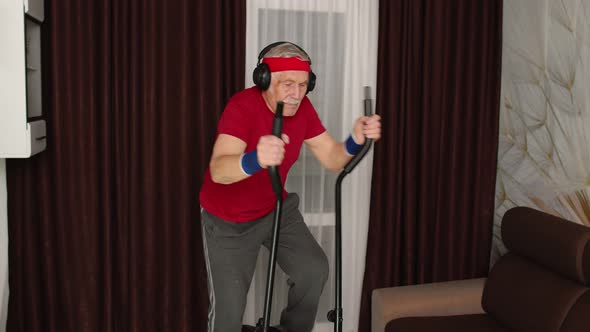 Healthy Elderly Senior Grandfather Model Exercising Sport Workout on Orbitrek in Room at Home