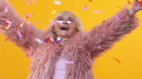 Happy Retired Female Throwing Up Colorful Confetti Slow Motion, Having Fun Party