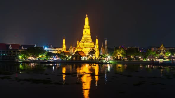 time lapse of Wat Arun Temple with Chao Phraya river at night in Bangkok, Thailand