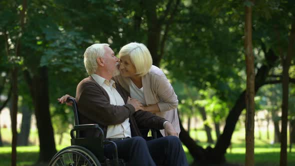 Mature Couple Resting in Park Looking at Grandkids, Man Sitting in Wheelchair