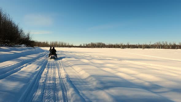 POV View of Two Snowmobile Rides Through the Pine Forest in Slow Motion Footage