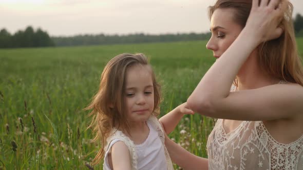 Mom and Daughter in the Green Field Enjoy Nature