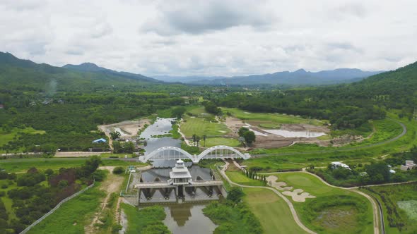 Aerial top view of Tha Chomphu White Bridge, Lamphun, Thailand with lake or river