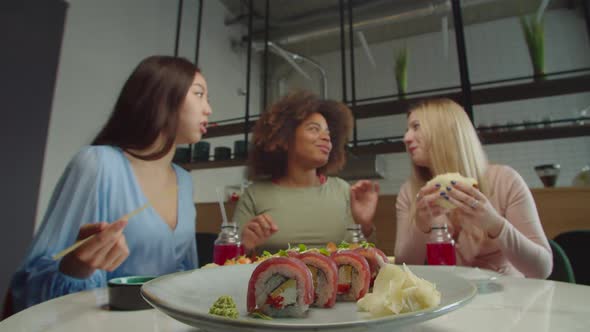 Pretty Asian Woman Eating Tasty Sushi During Lunch with Girlfriends