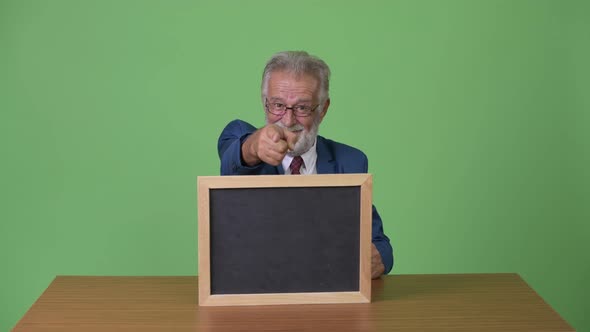 Handsome Senior Bearded Businessman Against Green Background