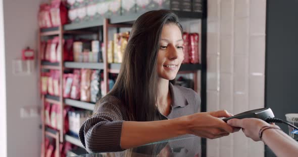 the Beautiful Young Lady Pays with the Card in the Cafe Hold Down the Button