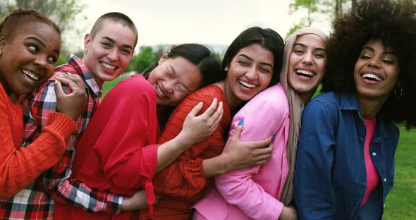 Young multiracial women having fun laughing together at city park - Diversity concept