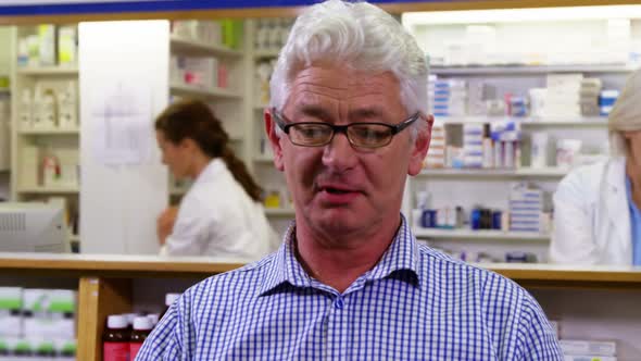 Customer holding prescription while checking medicine in pharmacy