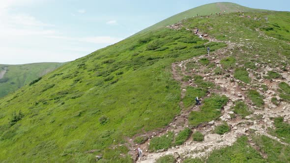 Aerial View of Young Tourists Walking Along a Mountain Trail to the Top of the Mountain